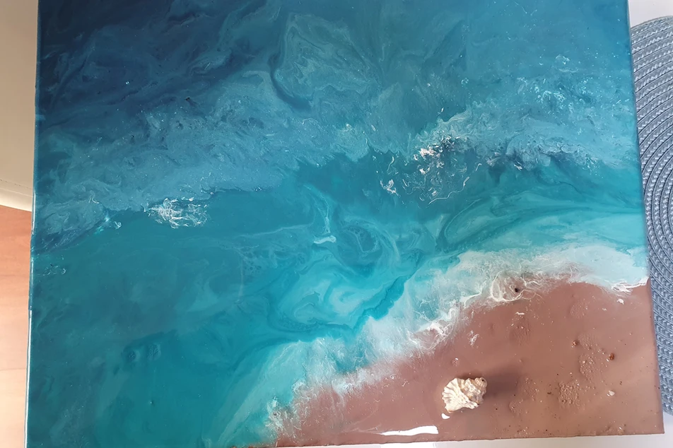 Ocean-inspired artwork with swirling turquoise water, white surf and a shell on a sandy shore