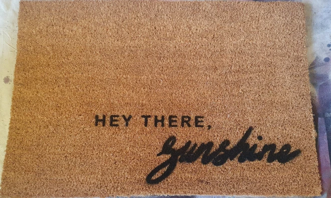 Coir doormat with black lettering reading 'Hey there, sunshine'